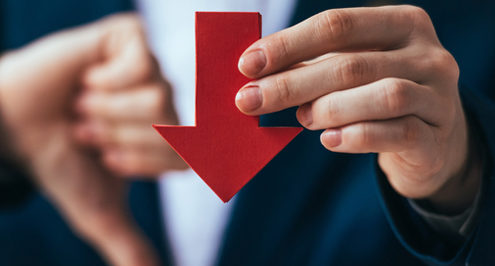 Marketing man in a suit holding a red downward pointed arrow giving a thumbs down.